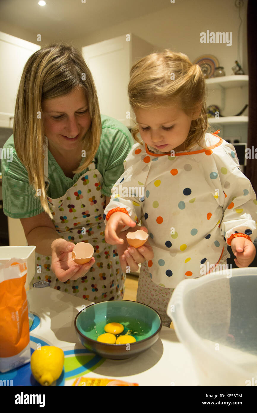 Mutter und Tochter das Mischen von Zutaten in der Vorbereitung für das Backen eines Kuchens Stockfoto