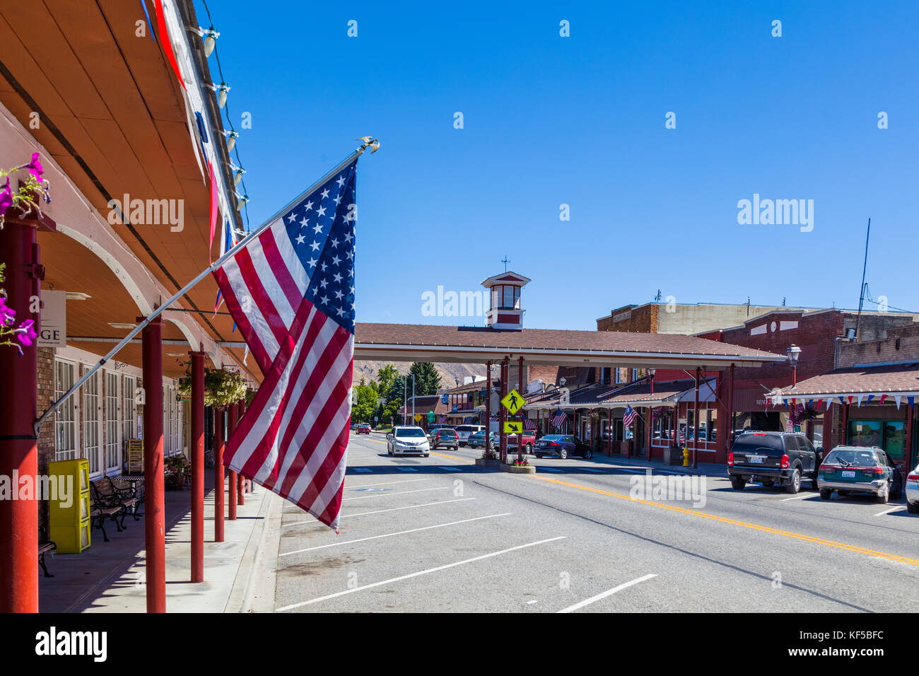 Amerikanische Flagge mit überdachtem Quersteg im Hintergrund auf der Cottage Ave in der Innenstadt von Cashmere, einer Stadt im Chelan County, Washington, USA Stockfoto