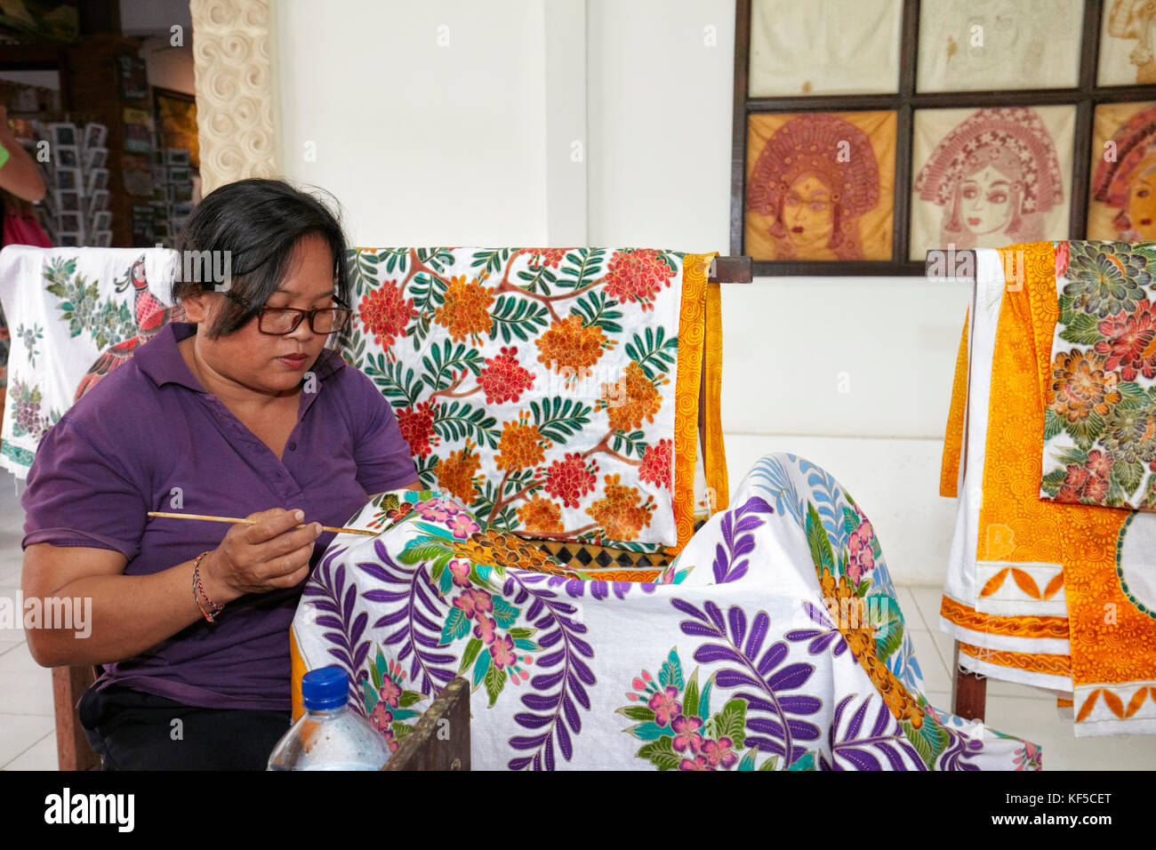 Indonesische Kunsthandwerkerin malt Batik in einem Workshop. Batubulan Dorf, Ubud Gebiet, Bali, Indonesien. Stockfoto