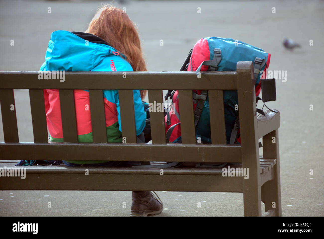 Junge Mädchen Schüler Frau sitzt auf der Bank mit bunten Rucksack auf dem George Square Glasgow Stockfoto