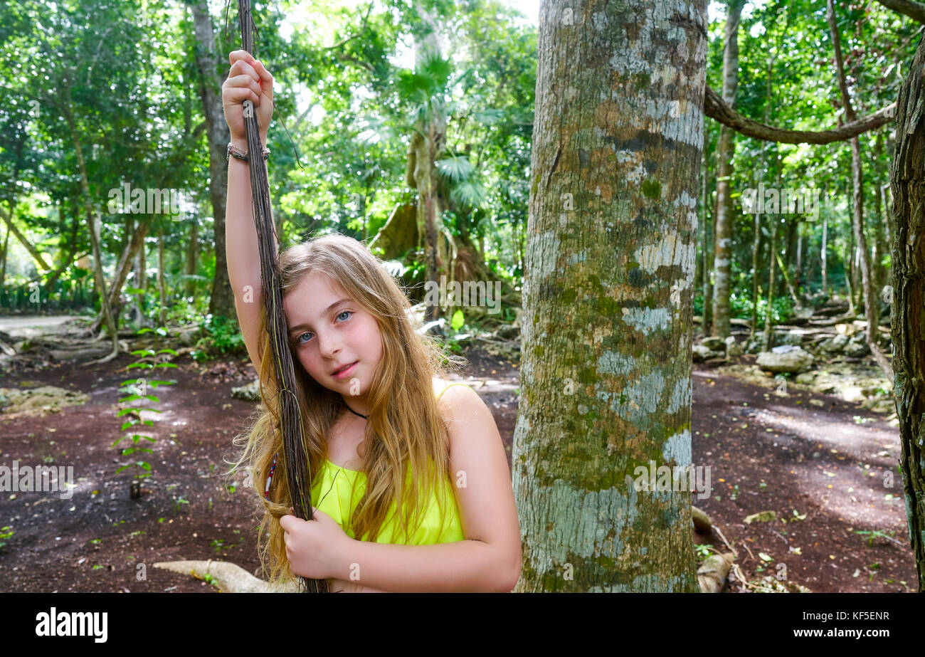 Kaukasische Mädchen spielen mit Lianen im Regenwald Dschungel Stockfoto