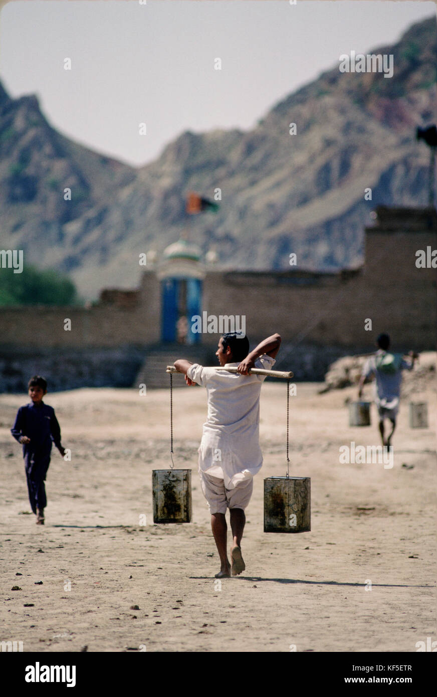Leute, die Wasser aus dem Fluss Indus in Mari Dorf in der Nähe von Kalabagh mit Salz Bereich im Hintergrund, Punjab, Pakistan. Stockfoto