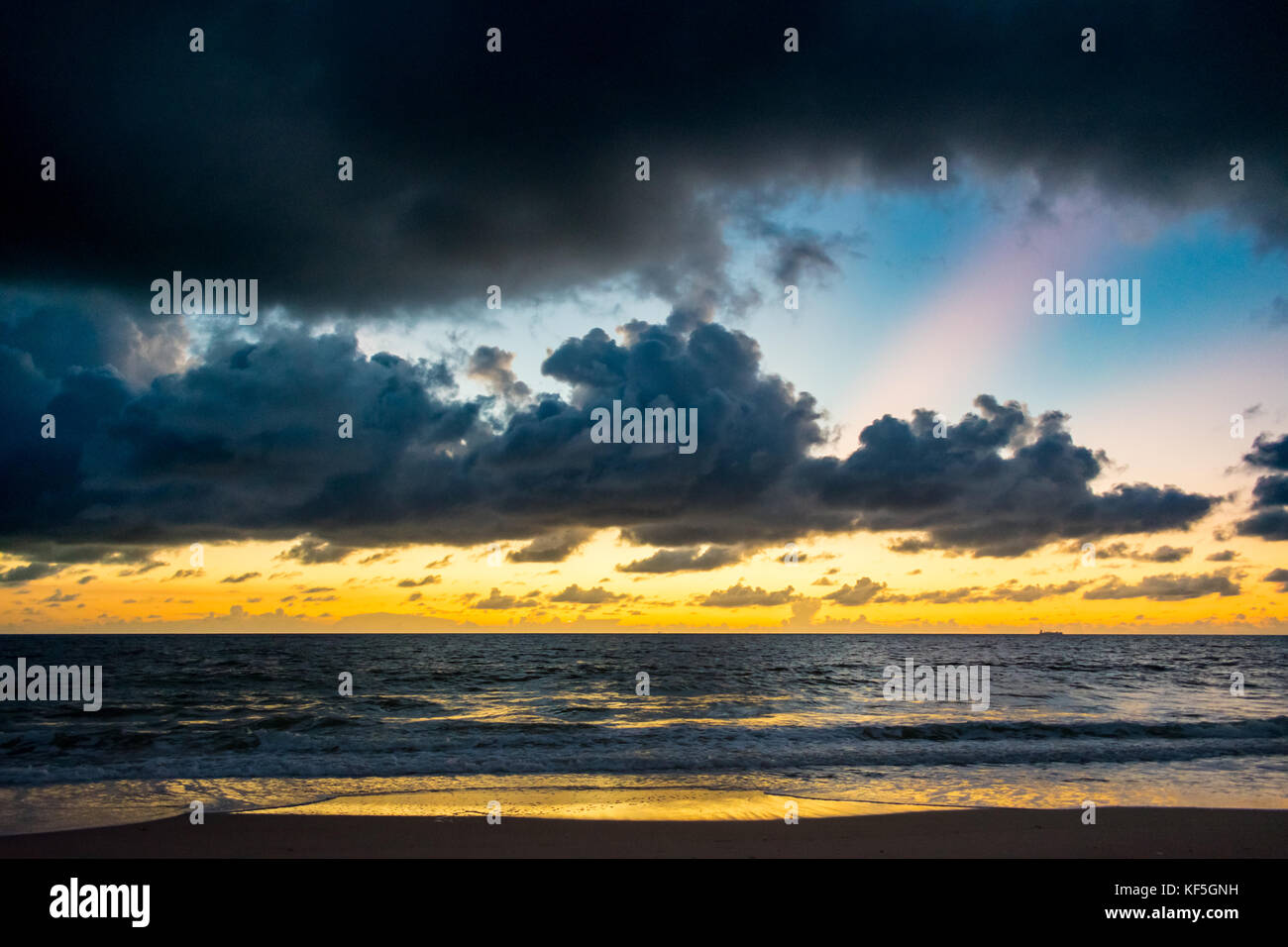 Farbige Wolkenschichten über den Ozean an einem warmen Morgen am Strand Stockfoto