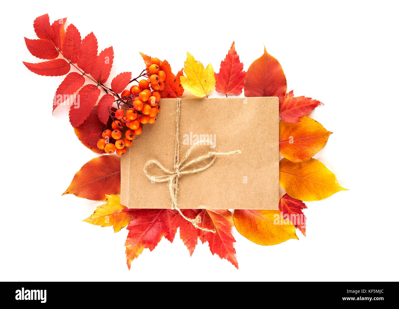 Handwerk Papier Geschenk Umschlag flach auf roten und gelben Blätter im Herbst auf weißem Hintergrund legen. Ansicht von oben. Stockfoto