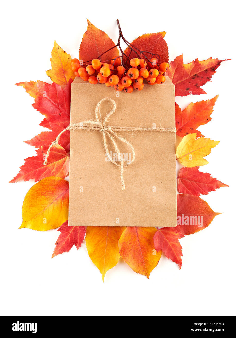 Handwerk Papier Geschenk Umschlag flach auf roten und gelben Blätter im Herbst auf weißem Hintergrund legen. Ansicht von oben. Stockfoto