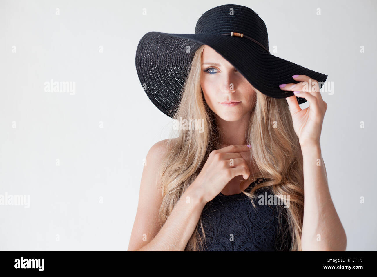 Modische Mädchen in einen Hut mit Krempe stellt für Werbung Stockfoto