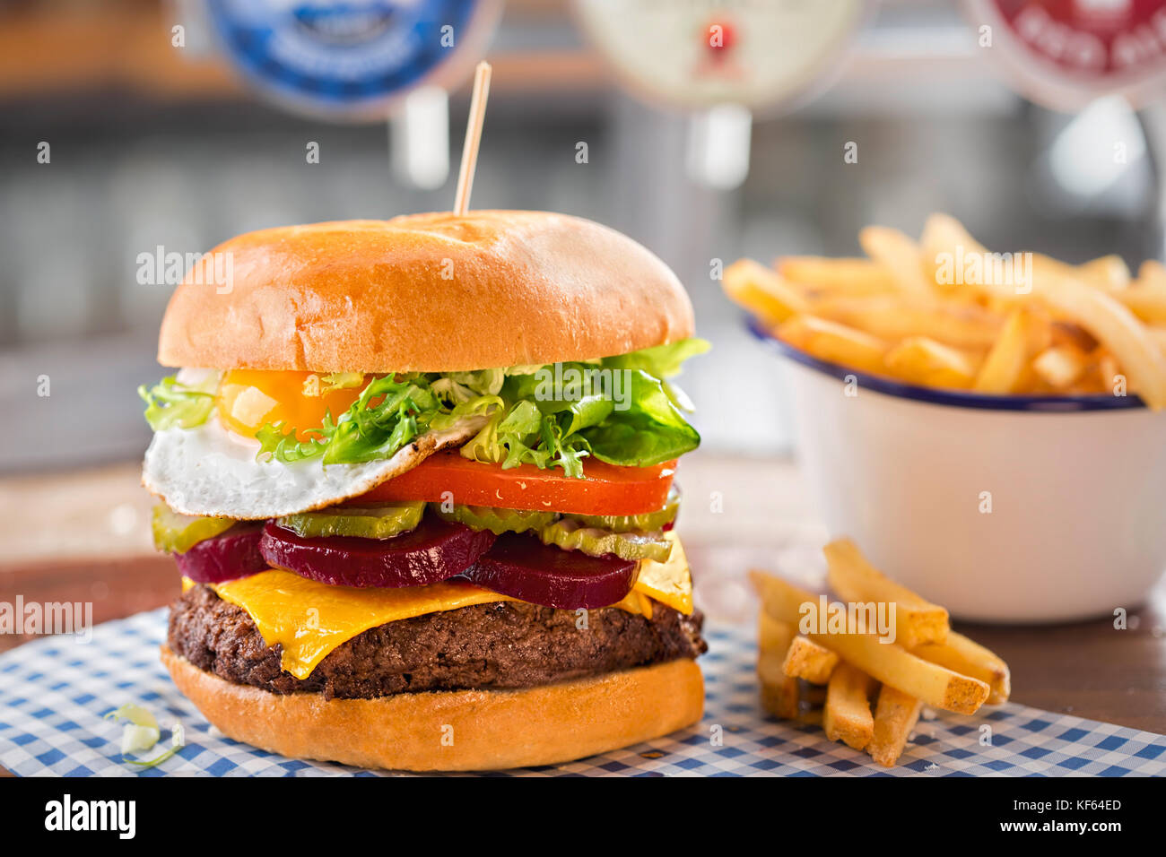 Beef Burger mit Käse, Salat, Tomaten, Rote Bete &amp; Essiggurke, gekrönt ...