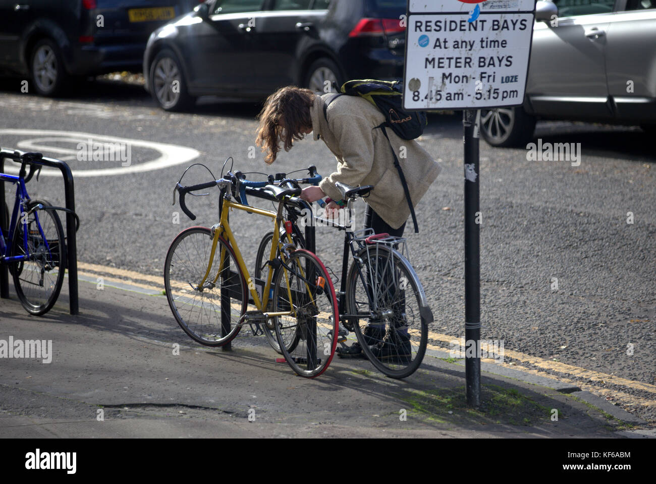 Mädchen Entriegelung Fahrrad auf dem Bordstein Straße, Gehsteig Bürgersteig Stockfoto