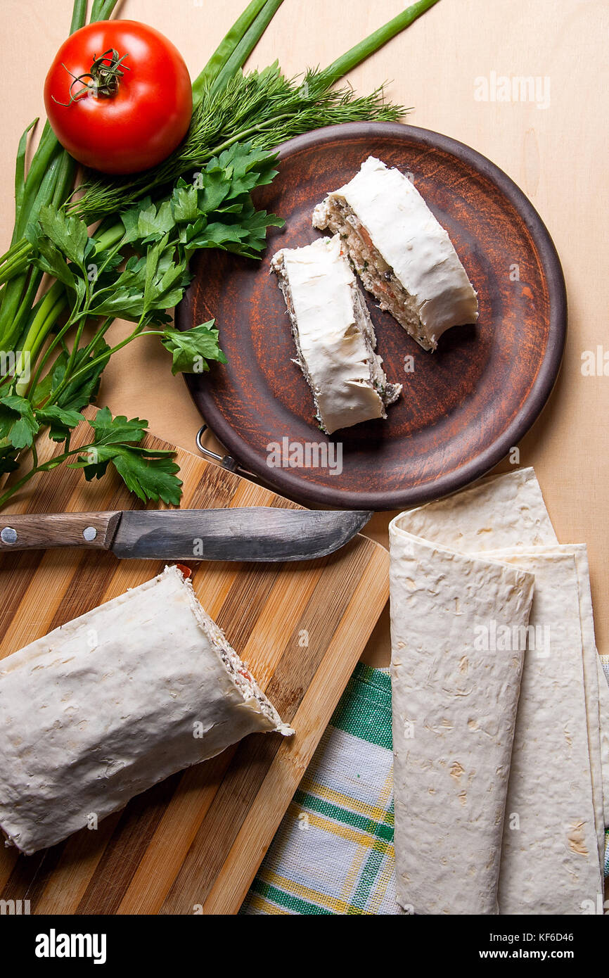 Stücke von dünnen armenische Fladenbrot oder lavash eingewickelt Tomaten, Hüttenkäse oder Quark, Hähnchenfleisch, Tomaten und Kräutern - Dill, Zwiebeln, Petersilie und Bro Stockfoto