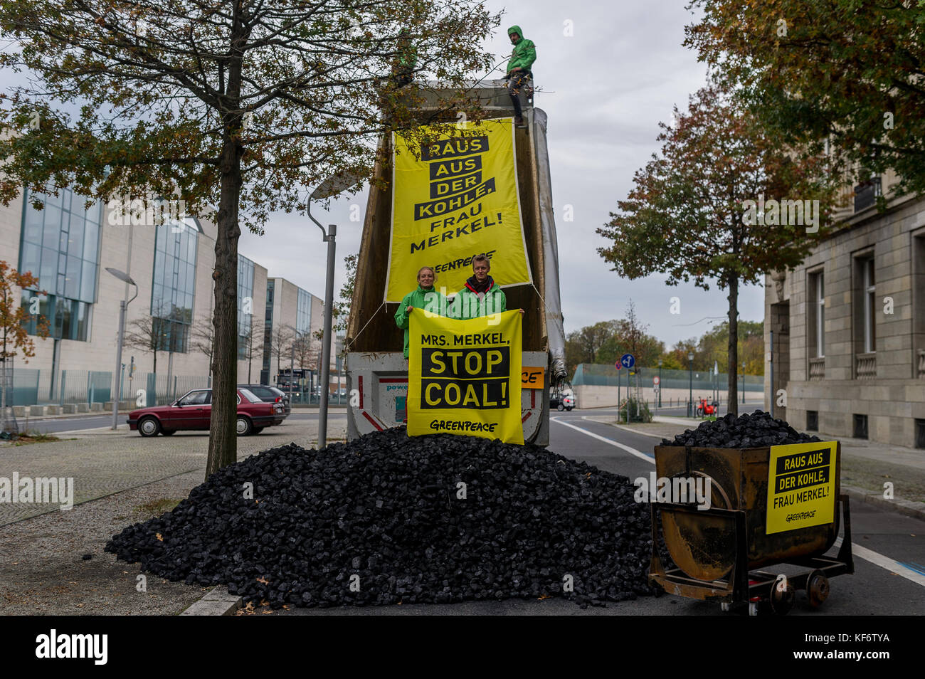 Berlin, Deutschland. Oktober 2017. Greenpeace-Aktivisten werden während einer Demonstration gesehen, wie sie einen LKW voller Kohle entladen haben. Greenpeace-Aktivisten haben vor dem Kanzleramt in Berlin 10 Tonnen Kohle abgeladen. Mit der Aktion wollen sie ihre Nachfrage nach einem schnellen Kohleabgang ausleihen. Die künftige Klima- und Energiepolitik steht im Mittelpunkt der Sondierungsgespräche der Union, der FDP in Berlin in Jamaika. Quelle: Markus Heine/SOPA/ZUMA Wire/Alamy Live News Stockfoto