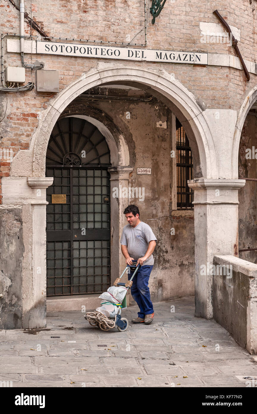 Venedig, Italien. Ein Portier, eine Lieferung in einer Seitenstraße, Sotoportego del Magazen im Stadtteil Cannaregio Stockfoto