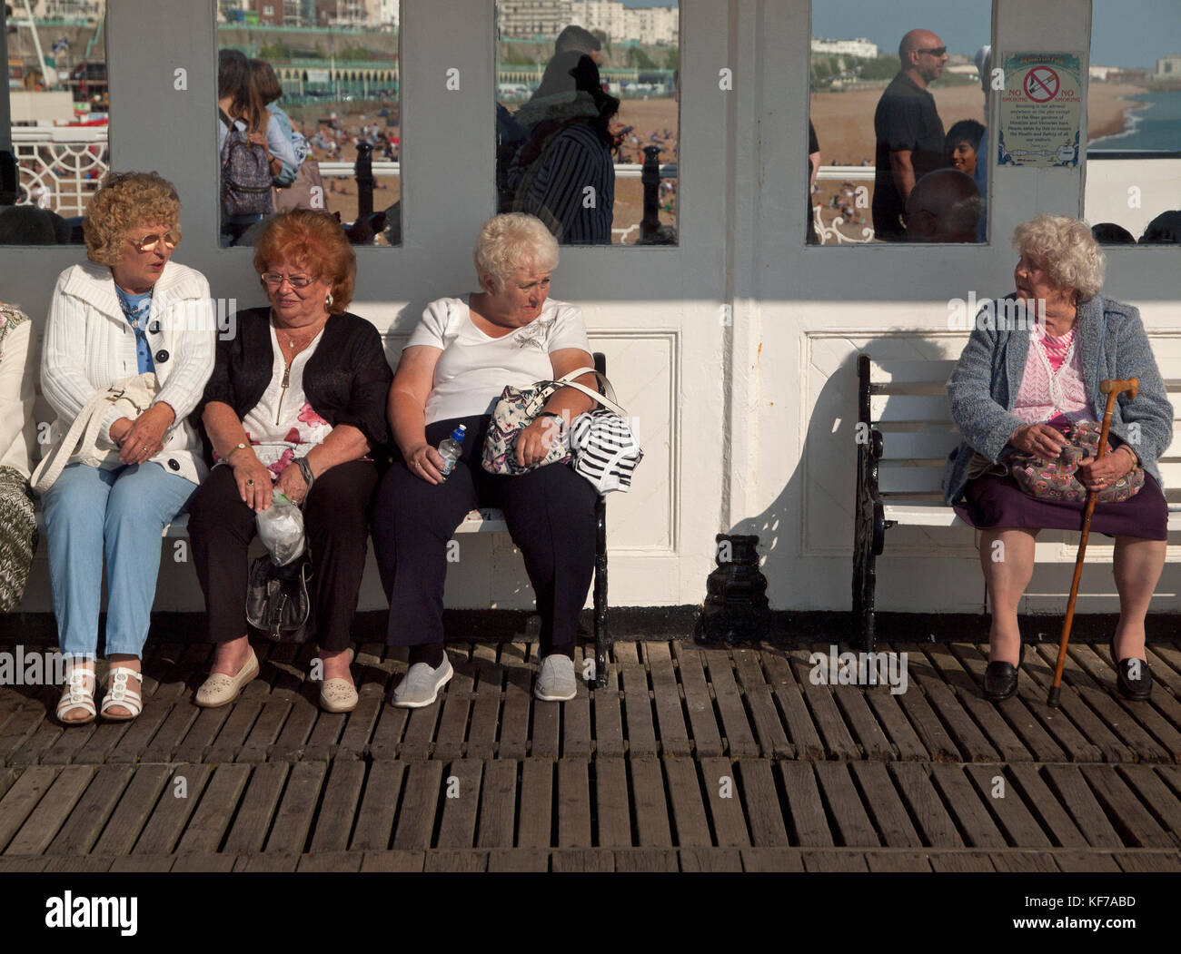 Alte Damen genießen Sie sitzen an einem sonnigen Standort auf Brighton Pier Stockfoto