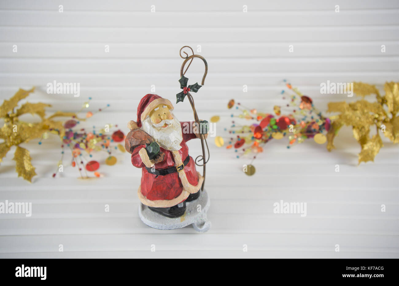 Fröhlich bunte Weihnachten fotografie Bild der traditionellen Holz santa stocking Kleiderbügel Haken mit gold Rot hell Holly und xmas Schmuckstücke im Hintergrund Stockfoto