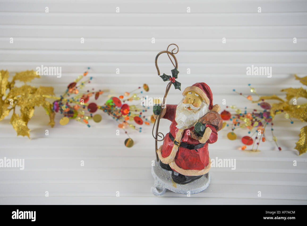 Fröhlich bunte Weihnachten fotografie Bild der traditionellen Holz santa stocking Kleiderbügel Haken mit gold Rot hell Holly und xmas Schmuckstücke im Hintergrund Stockfoto