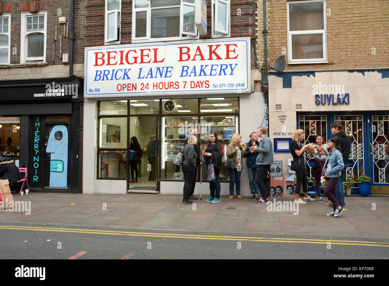 Menschen essen Bagels außerhalb des beliebten Beigel Bake - Eine 24-shop in Brick Lane London England Stockfoto