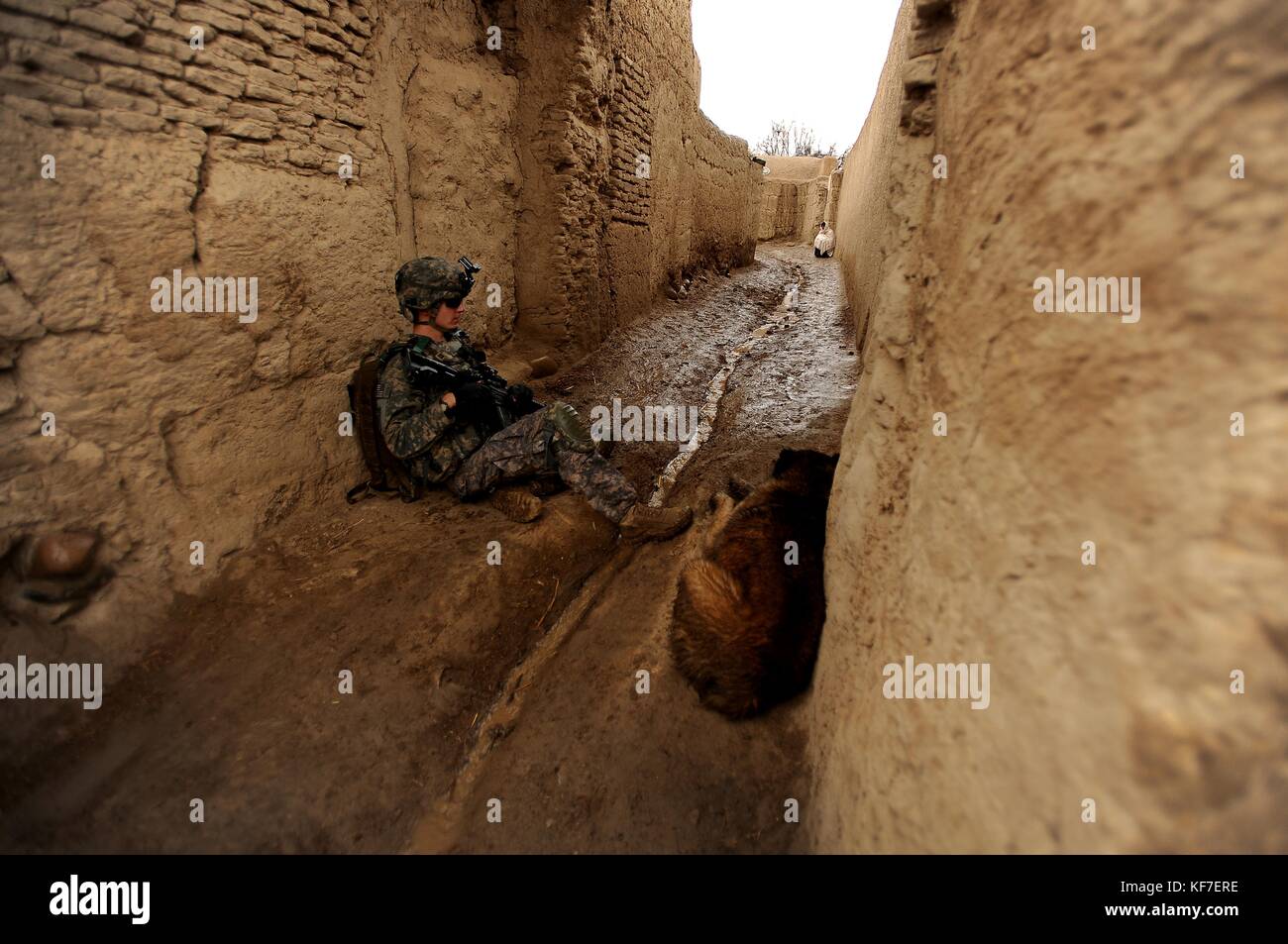 Ein Soldat der US-Armee macht eine Pause mit einem lokalen afghanischen Hund während einer Patrouille für die Operation Enduring Freedom 5. Februar 2010 in Terot Kulacha, Afghanistan. (Foto von Kenny Holston via Planetpix) Stockfoto