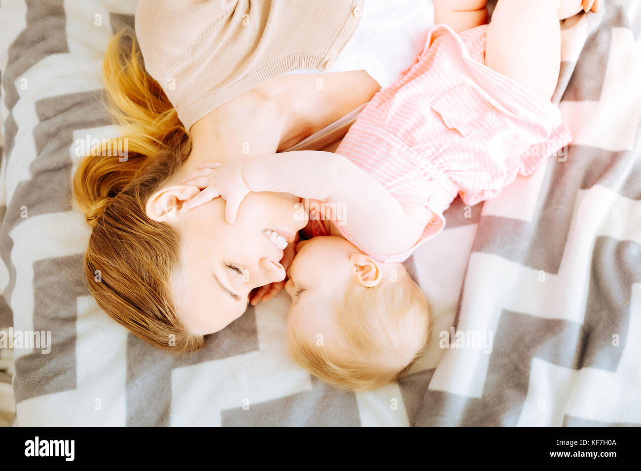 Adorable Baby Mädchen küsste ihre glückliche Mutter Stockfoto