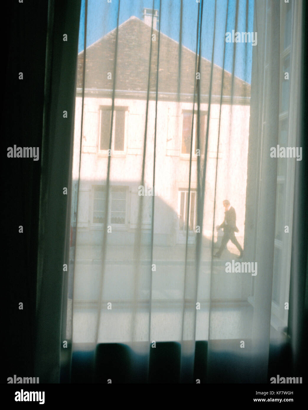 Frankreich, Burgund, Mann zu Fuß auf der Straße durch Fenster mit Vorhängen gesehen, Chablis Stockfoto