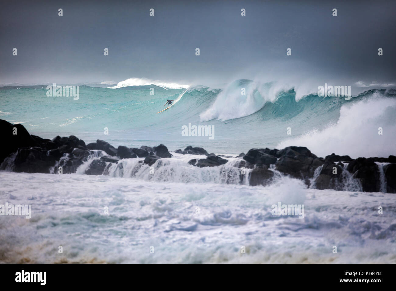 Hawaii, Oahu, North Shore, Surfern im Wasser am Waimea Bay Stockfoto