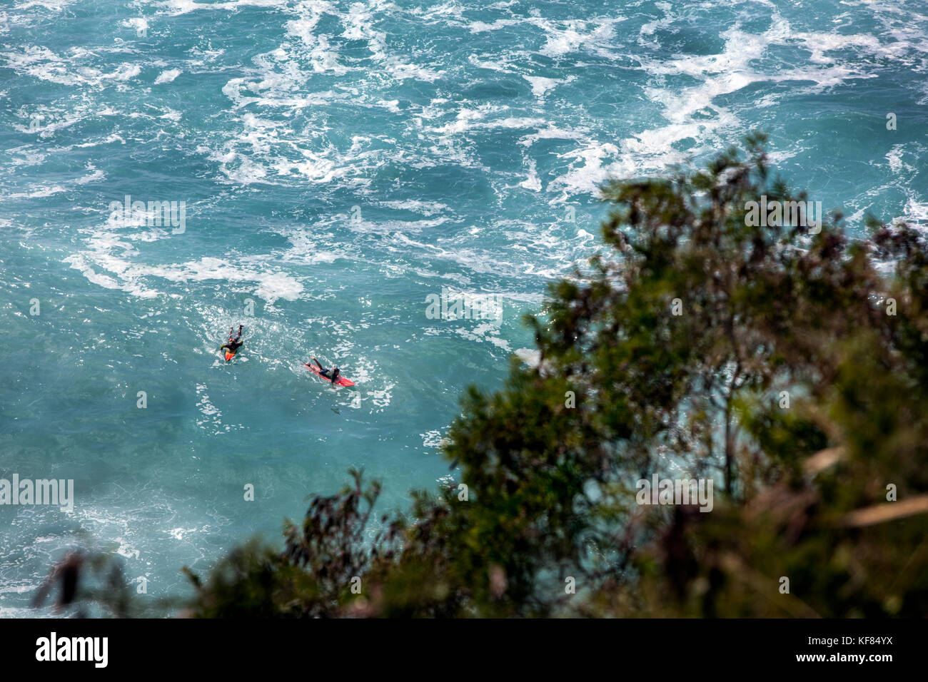 Hawaii, Oahu, North Shore, Surfern im Wasser am Waimea Bay Stockfoto