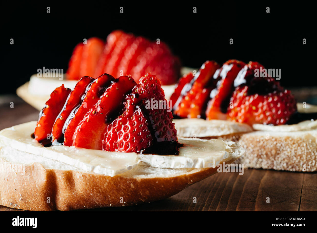 Kanapees mit Brie Käse, frische Erdbeeren auf Holzmöbeln im Landhausstil Oberfläche Stockfoto