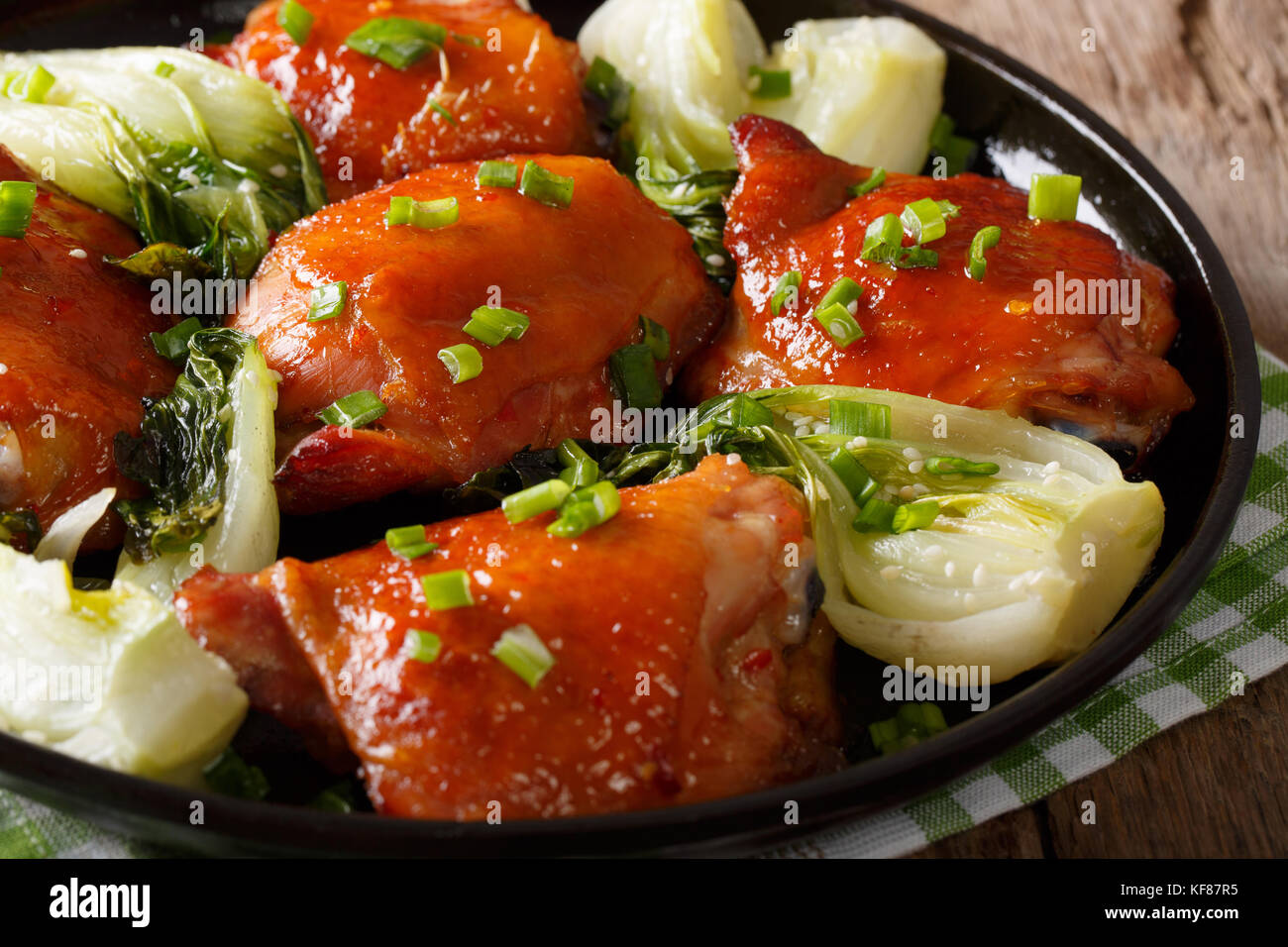 Gebratene Hühnerkeule mit Bok Choy und grüne Zwiebeln close-up auf einem Teller. Horizontale Stockfoto