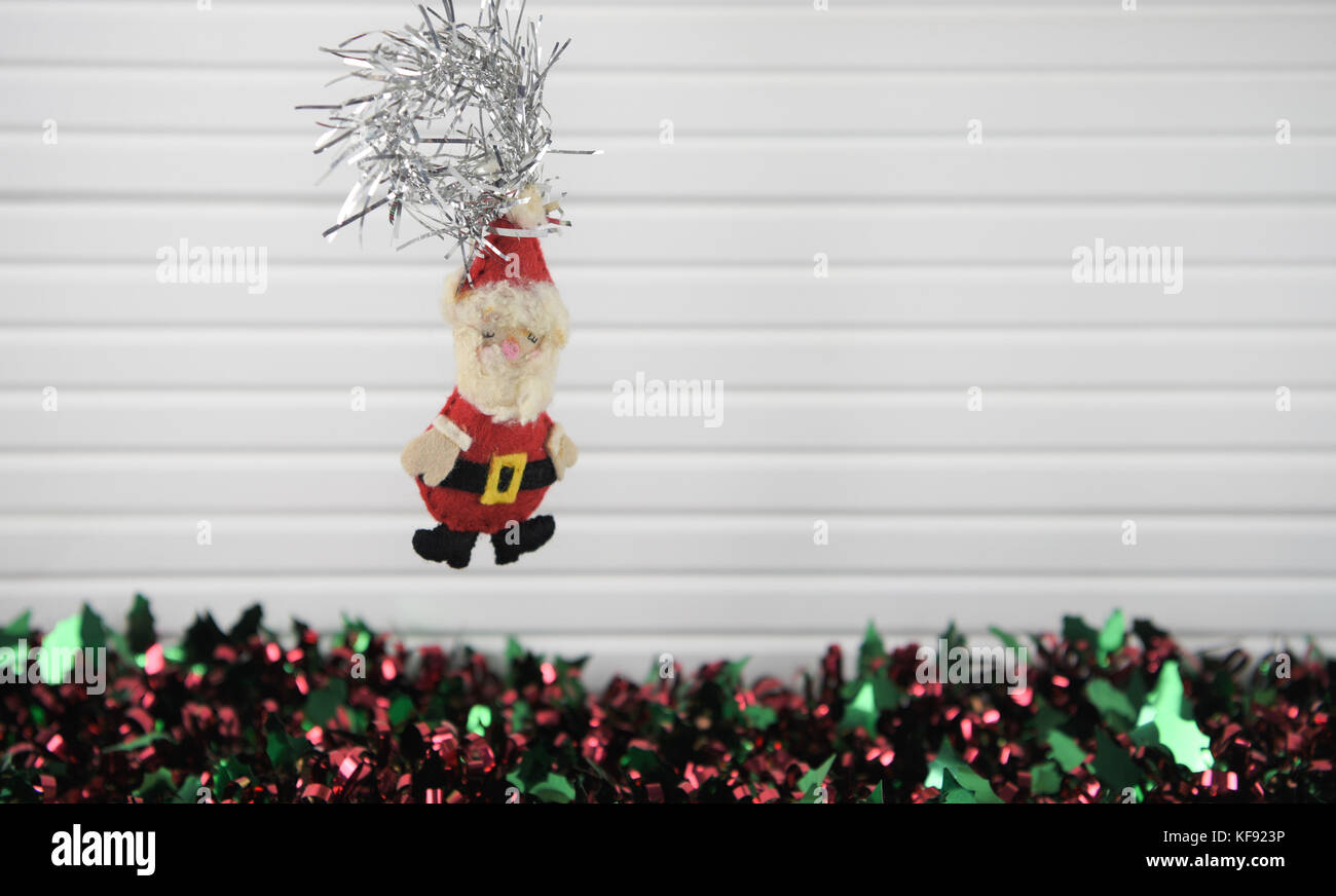 Weihnachten fotografie Bild von Xmas Tree Dekoration zum Aufhängen von Hand gefertigt santa claus aus weichem Filz mit buntem Lametta und weißem Holz Hintergrund Stockfoto