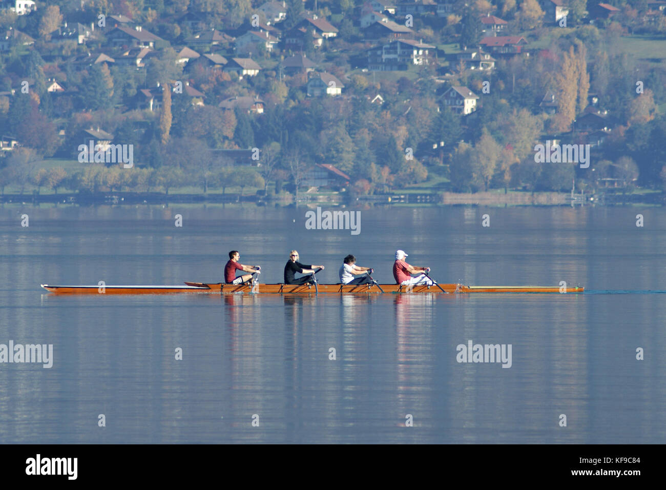 Racing Shell mit vier Menschen auf See von Annecy in Frankreich im Herbst Stockfoto