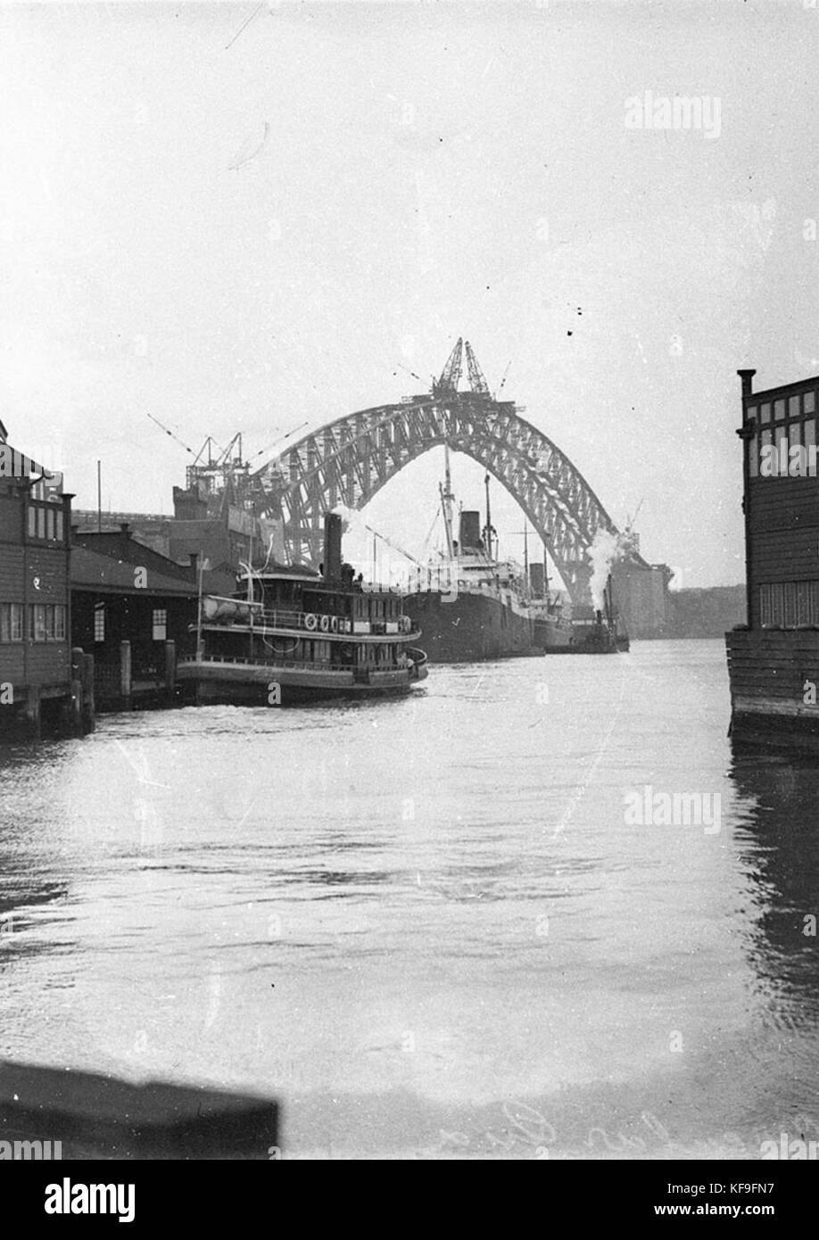 44107 Fähre Lady Denman zieht in Circular Quay mit zwei KLNM Schiffe im Hintergrund durch den ausgefüllten Bogen der Brücke gerahmt Stockfoto