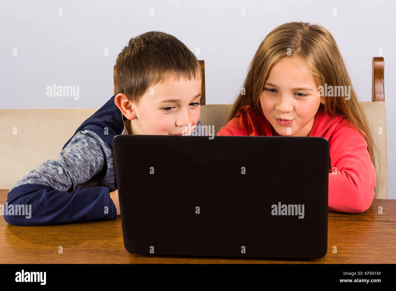 Kleinen Jungen und Mädchen Spaß haben auf einem Laptop. Stockfoto