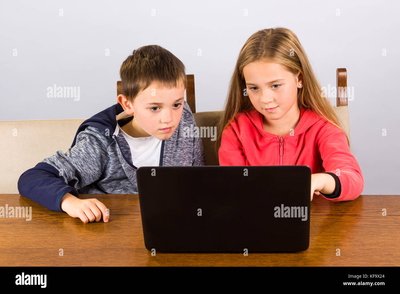 Kleine Jungen und Mädchen arbeiten auf einem Laptop. Stockfoto