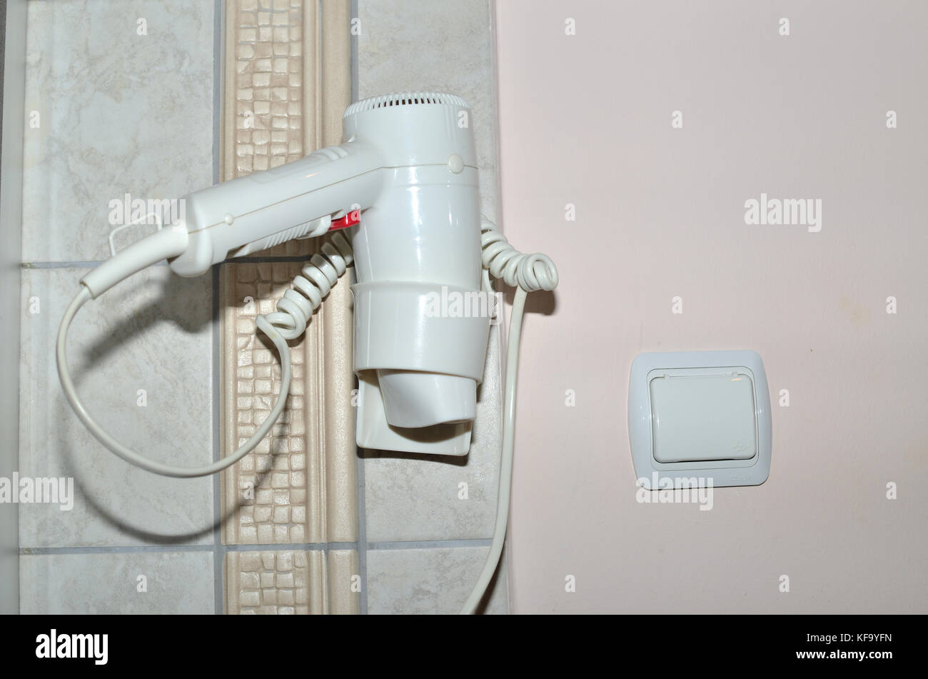Weißes Haar Trockner in die Halterung ein, an einer Wand in einem Badezimmer angebracht Stockfoto