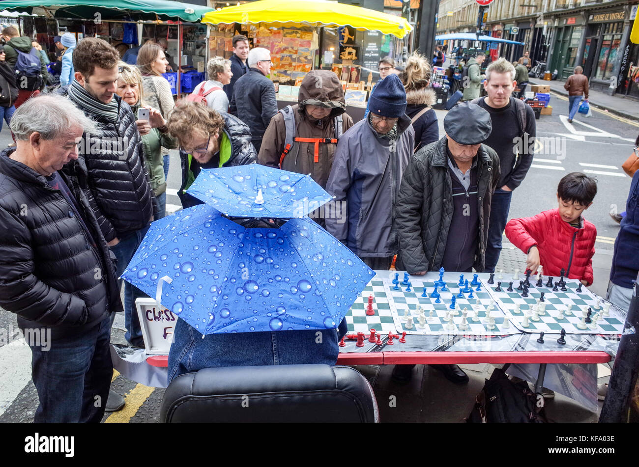 Brick Lane Schach - ein Schachspieler spielt 4 parallele Spiele mit Touristen und Passanten in die beliebten Londoner Brick Lane Markt am Sonntag Stockfoto