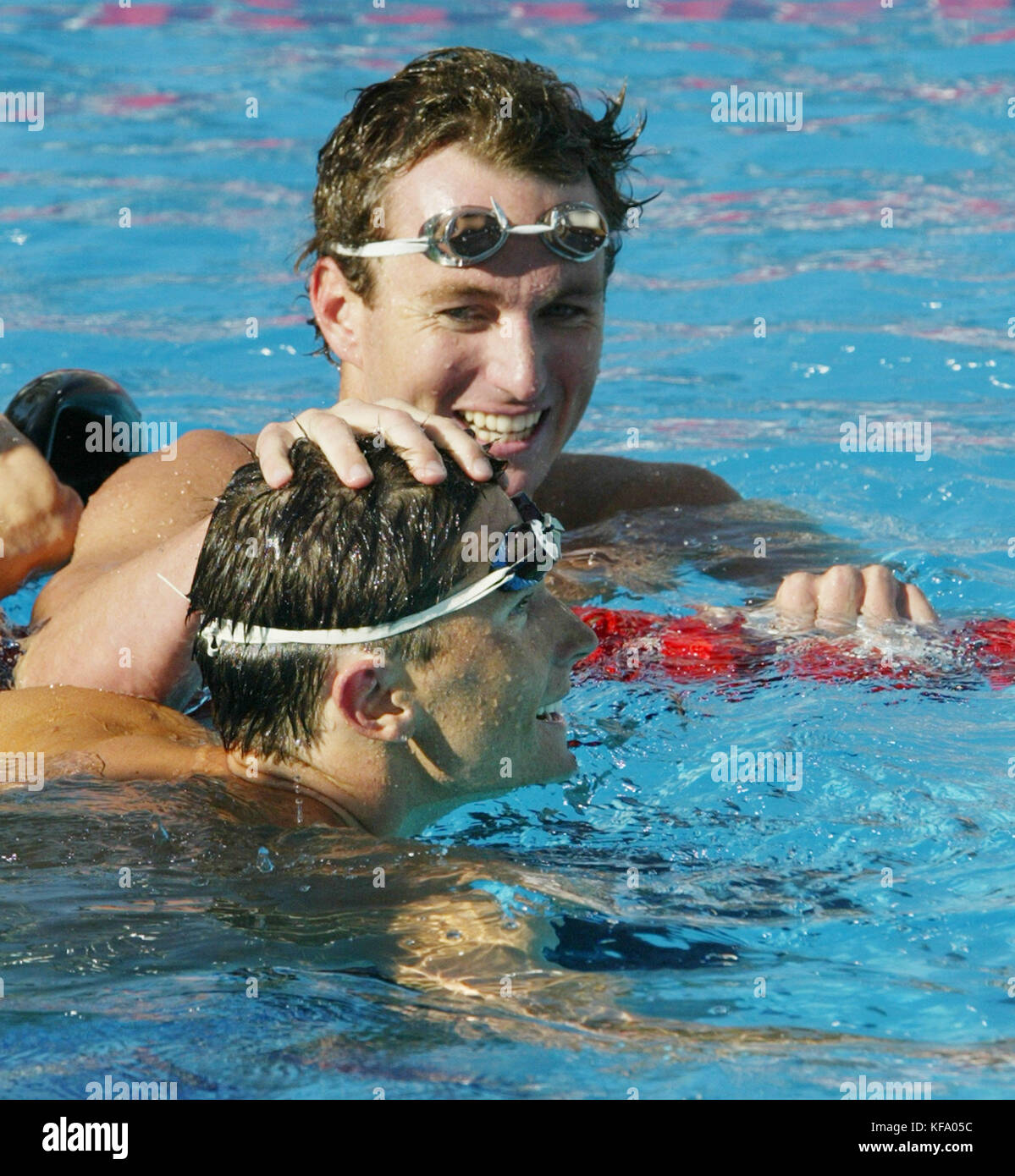 Us-Schwimmer Aaron Peirsol, top, klopft dem Kopf von Lenny krayzelburg, nachdem sie beide für die Olympischen Spiele in Athen im 100 der mens Meter Rücken an der US-amerikanischen olympischen Swimmingpool Versuche in Long Beach, Kalifornien, am Freitag, den 09. Juli 2004 qualifizierte. peirsol in einer Zeit von 53.64 Sekunden gewann. Foto von Francis specker Stockfoto