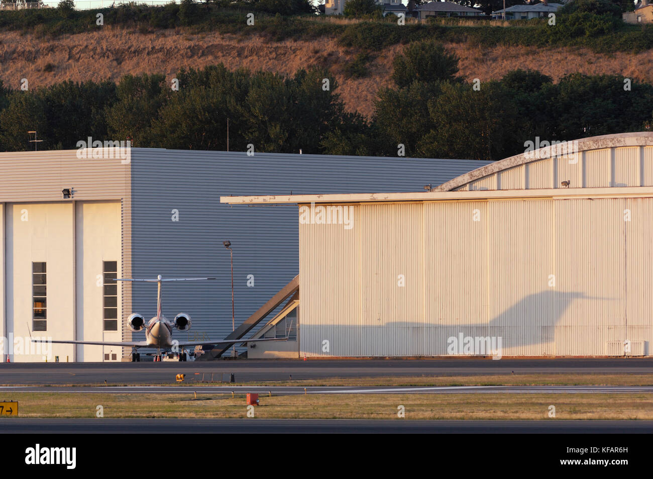 Eine Gulfstream 500 und es ist Schatten geparkt mit Hangar hinter Stockfoto
