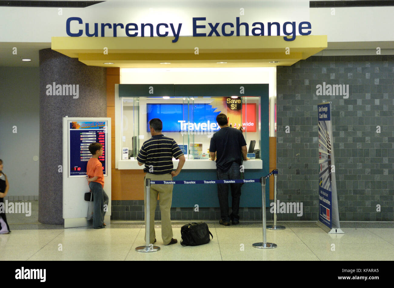 Passagiere mit Gepäck im Travelex Währungsumtausch stand in der TerminalC Stockfoto