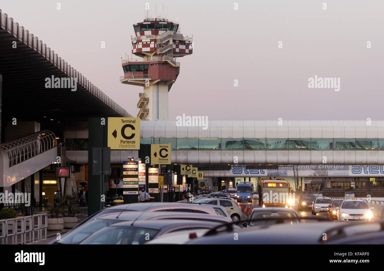 Autos auf dem Parkplatz, Zeichen für Airlines, überdachten Gang, TerminalC in englischer und italienischer Sprache mit dem Terminal und der Luftverkehrskontrolle - Abschleppen Stockfoto