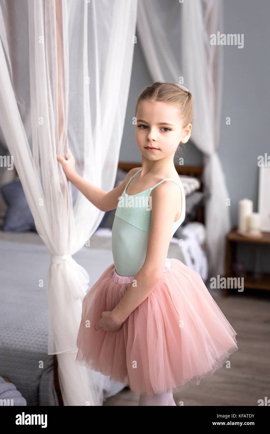 Süße kleine Ballerina in rosa Ballett Kostüm und Spitzenschuhe tanzt im Zimmer. Kind Mädchen studiert Ballett. Stockfoto
