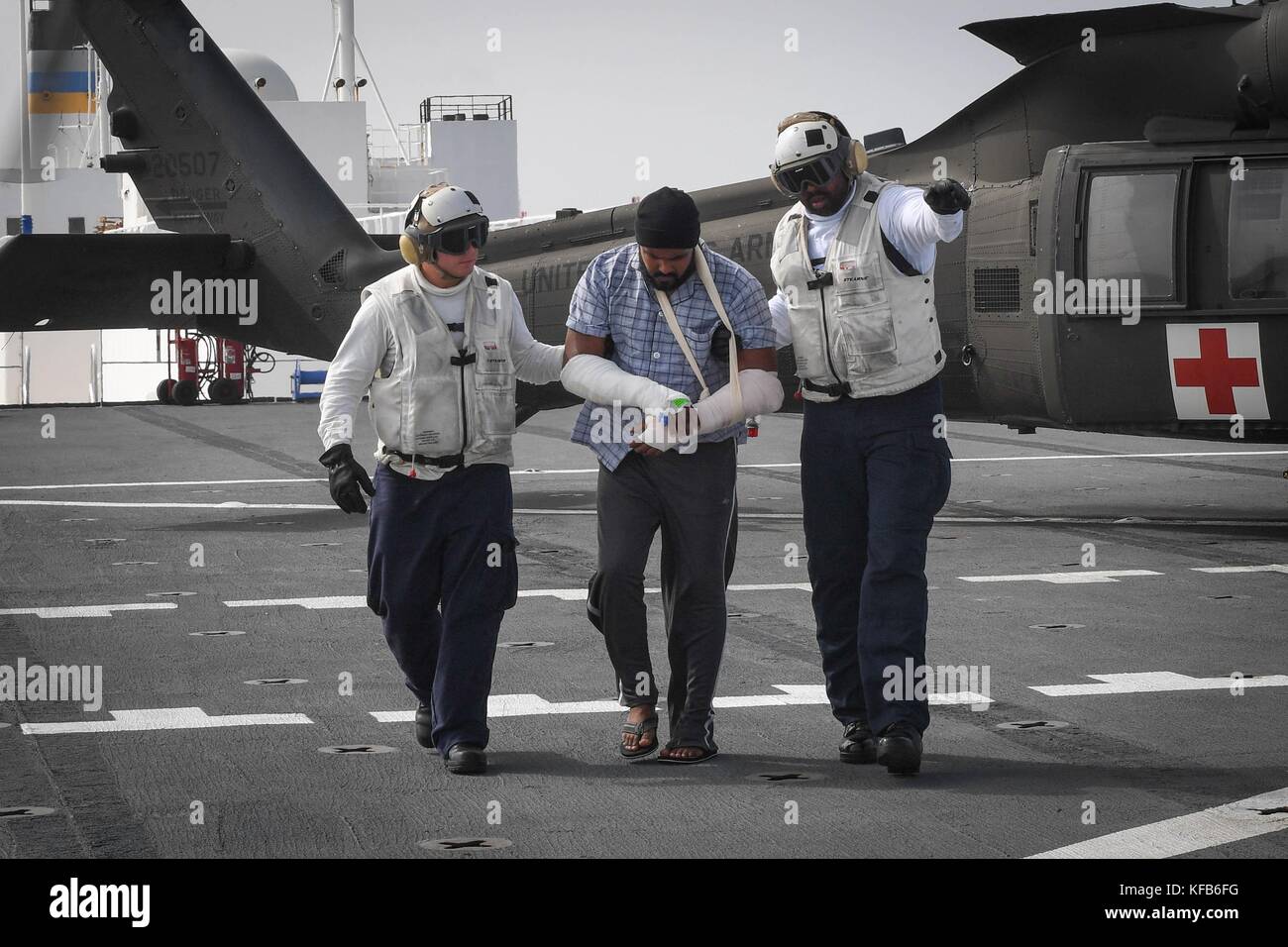 Us-Marine Seeleute an Bord der U.S. Navy mercy-Klasse Hospital Ship USNS Comfort escort Eine verletzte Puerto Rican Patienten während einer medizinischen Evakuierung im Gefolge von Hurrikan Maria 19. Oktober 2017 in das Karibische Meer. (Foto von Ernest r. Scott über planetpix) Stockfoto