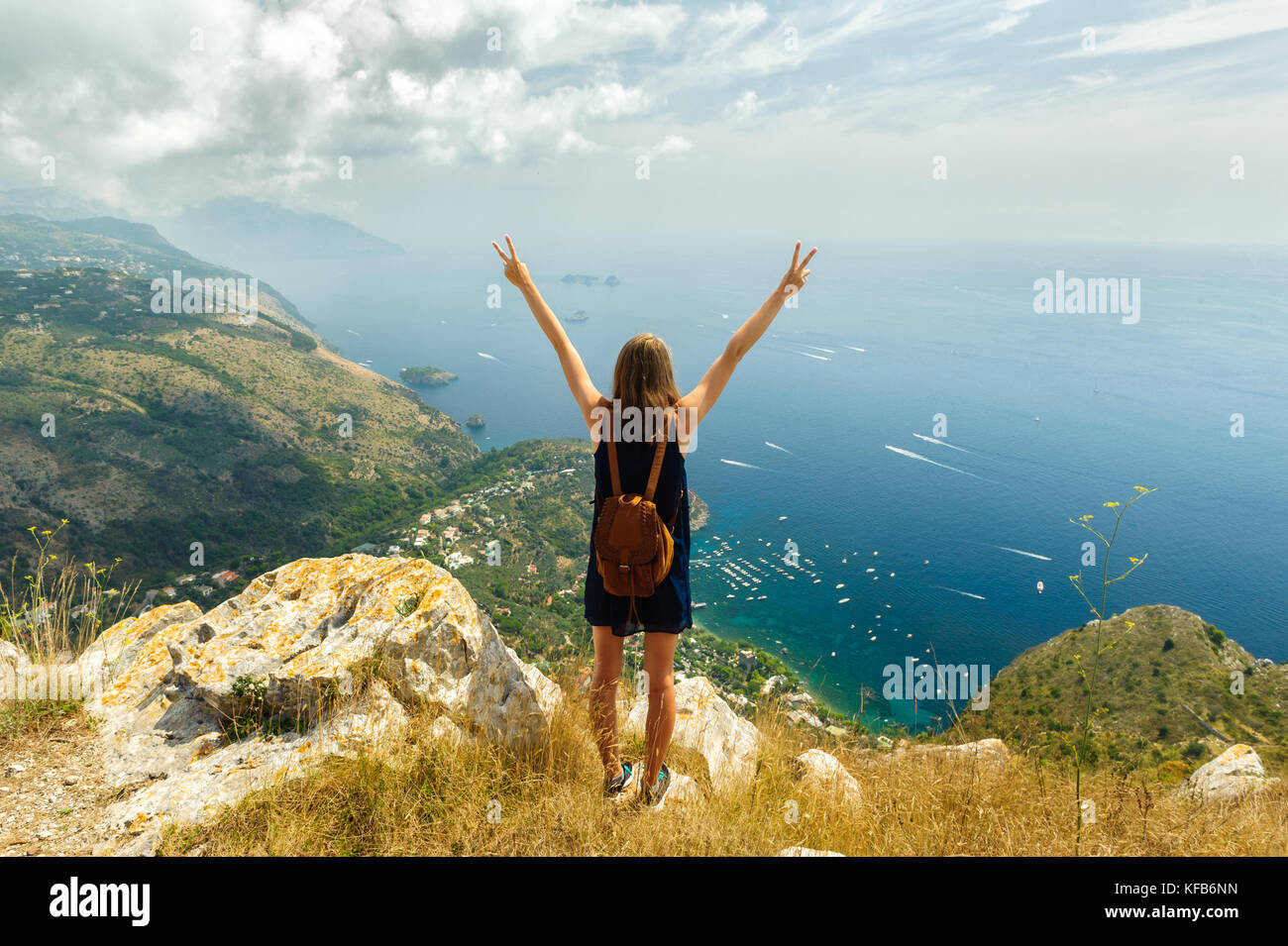 Junge Mädchen klettern auf einem Berg mit schöner Aussicht auf die Bucht von Sorrento und den Sieg Zeichen Stockfoto