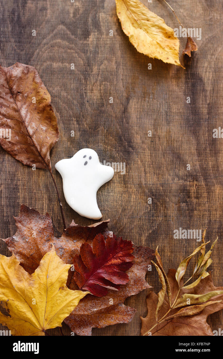 Lebkuchen ghost für Halloween, mit Blätter im Herbst eingerichtet, auf einem hölzernen Hintergrund. Selektive konzentrieren. Stockfoto