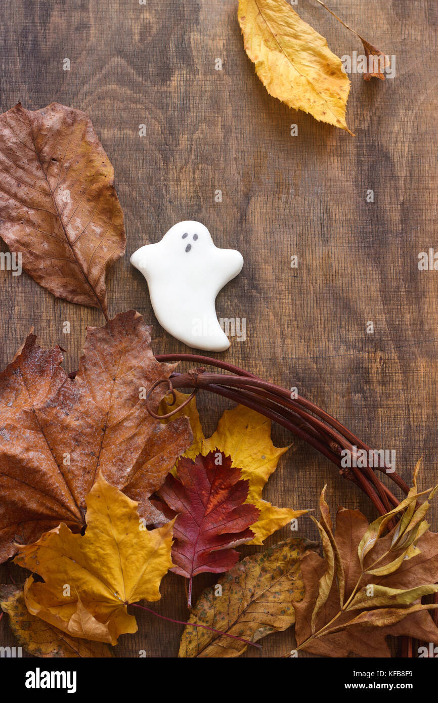 Lebkuchen ghost für Halloween, mit Blätter im Herbst eingerichtet, auf einem hölzernen Hintergrund. Selektive konzentrieren. Stockfoto