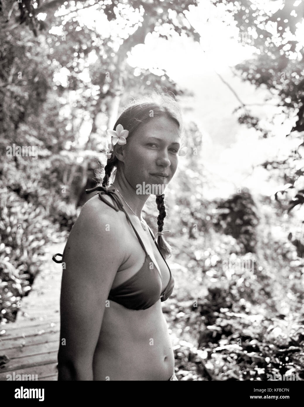 Fidschi, nördlichen Lau Inseln, eine junge Frau steht auf einem Weg durch einen üppigen Dschungel (B&W) Stockfoto