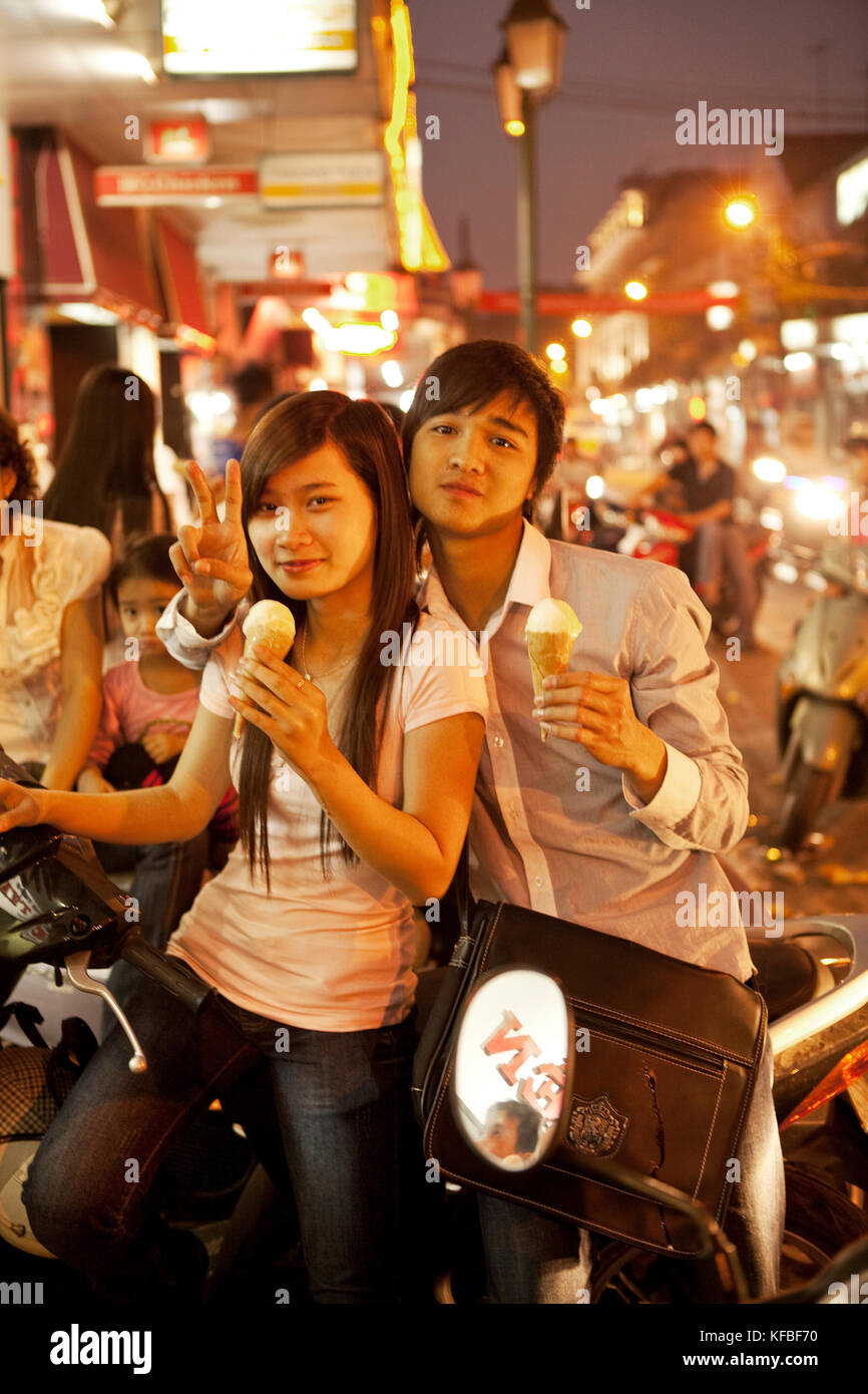 Vietnam, Hanoi, ein süßes junges Paar sitzt auf ihrem Moped Eis essen an einem heißen Sommerabend in der Innenstadt von Hanoi Stockfoto