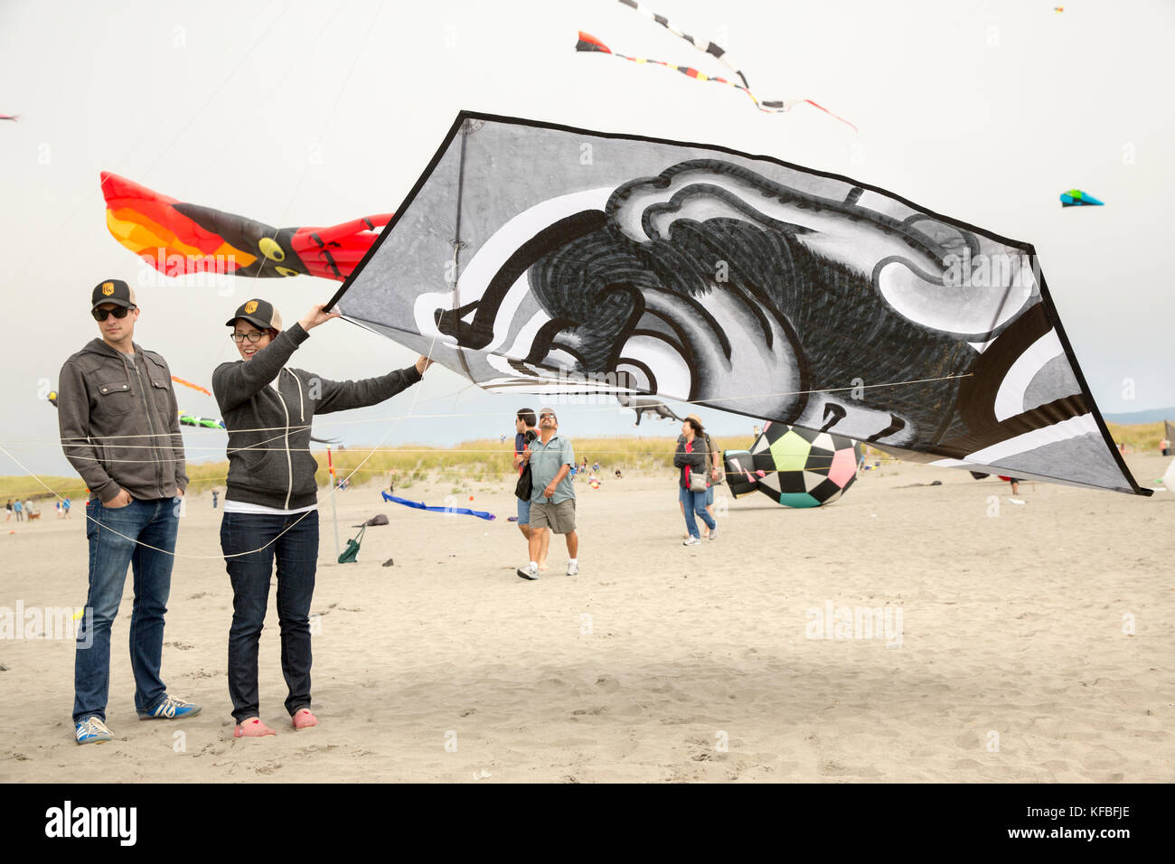 Usa, Washington State, Long Beach Halbinsel, internationale Drachenfest, Paar starten eine große, schwarze und weiße im japanischen Stil Kite Stockfoto