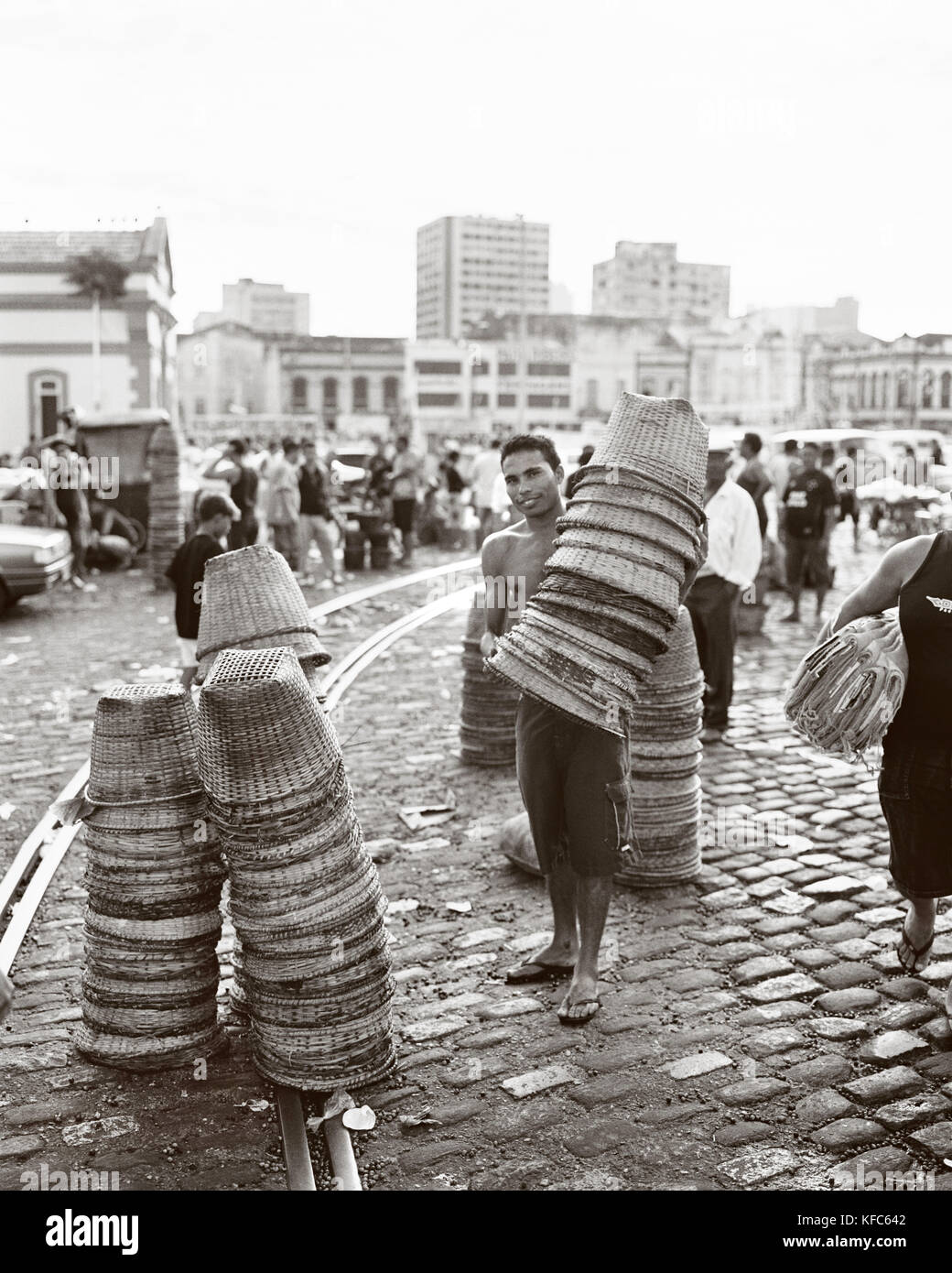 Brasilien, Belem, Südamerika, Korb vendor Holding der Körbe mit Gebäude im Hintergrund Stapel Stockfoto