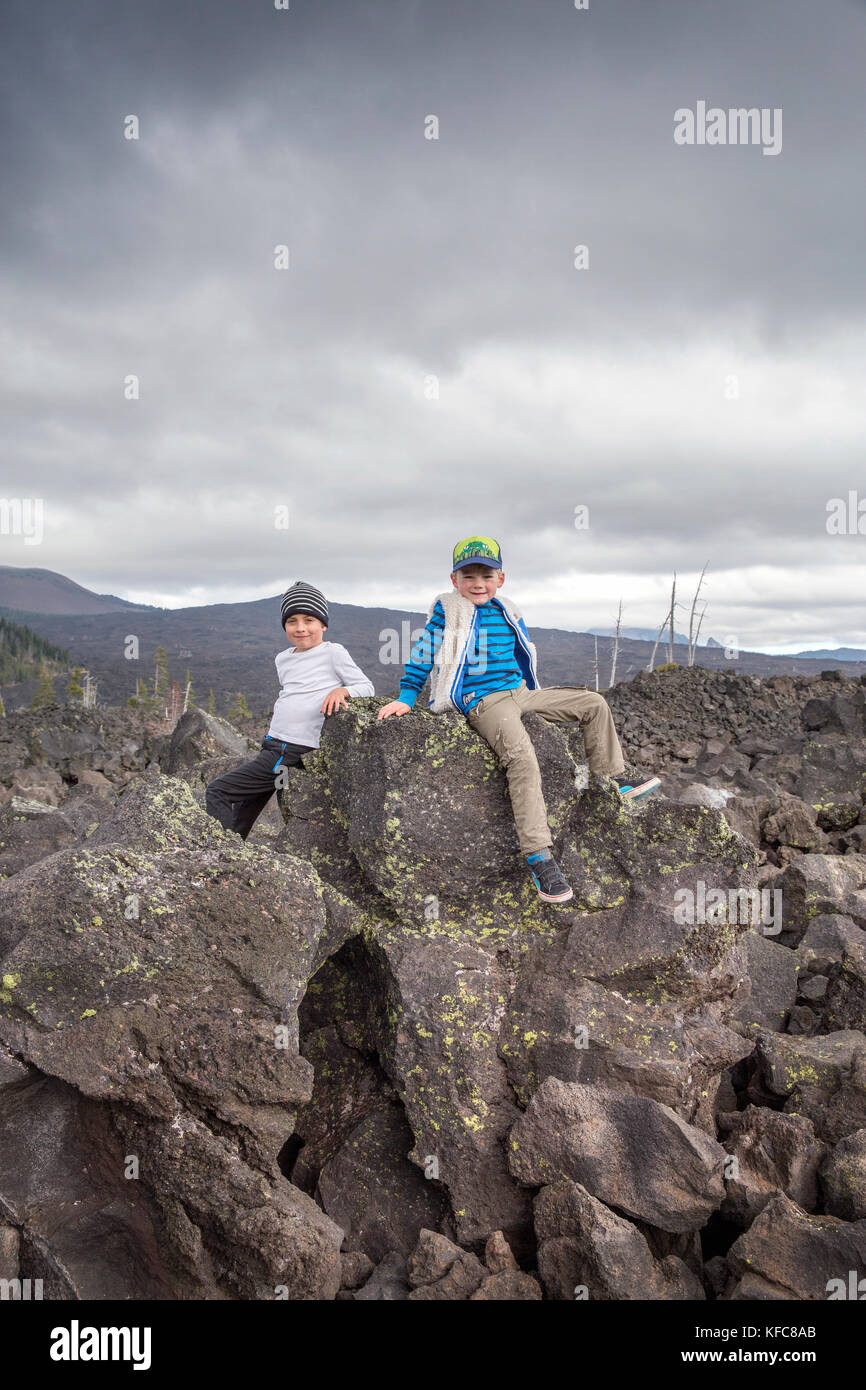 Usa, Oregon, Oregon Kaskaden, zwei Jungs auf den Felsen am Dee Wright Observatory spielen in der Mitte eines alten Lavastrom an der Oberseite der mcke Stockfoto