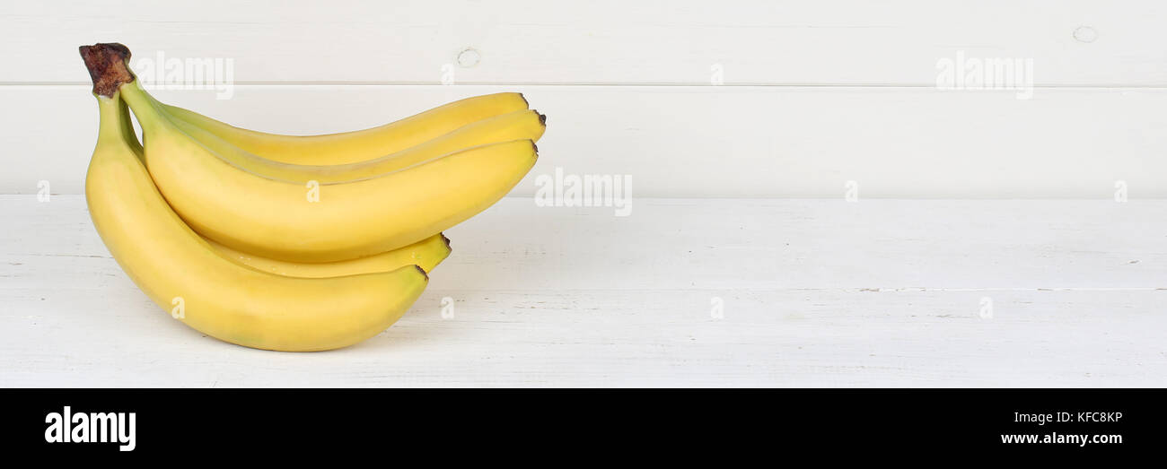 Bananen Obst Früchte banner Copyspace auf Holzbrett Holz Lebensmittel Stockfoto