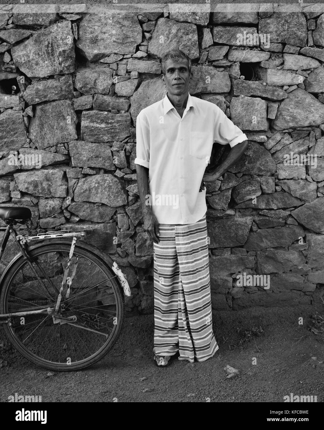SRI LANKA, Asien, Porträt der Mann, der die Mauer aus Stein (B&W) Stockfoto