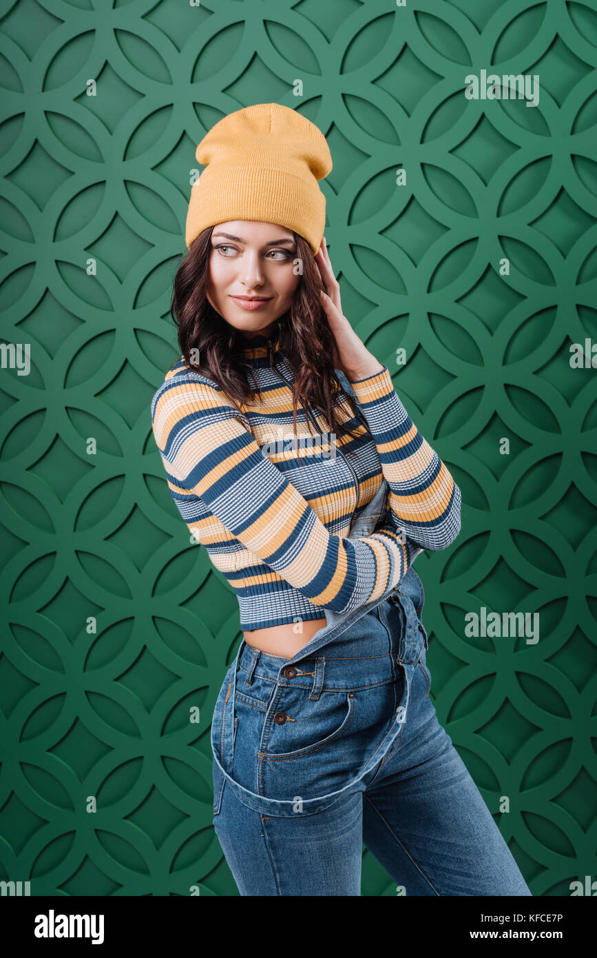 Frau in Pullover, Hut und Overalls posing Stockfoto